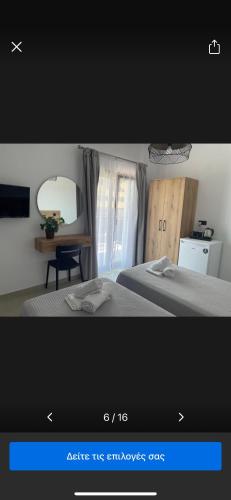 a picture of a room with two beds and a mirror at SENSIMAR Rooms To Let in Ouranoupoli