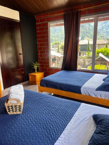 a bedroom with two beds and a window at Anagrama house in Baños