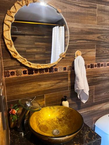 a bathroom with a gold sink and a mirror at Anagrama house in Baños