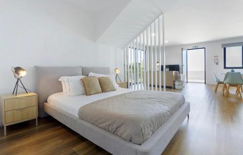 a bedroom with a large bed and a dining room at Modern Sea View Studio with Private Parking in Gaula