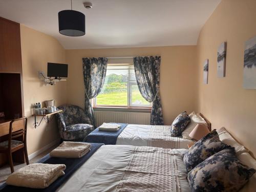 a hotel room with two beds and a window at Corrib View Villa - Guest Accomodation in Cong