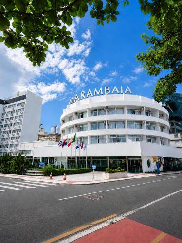 a large white building with a sign on it at Marambaia Hotel e Convenções in Balneário Camboriú