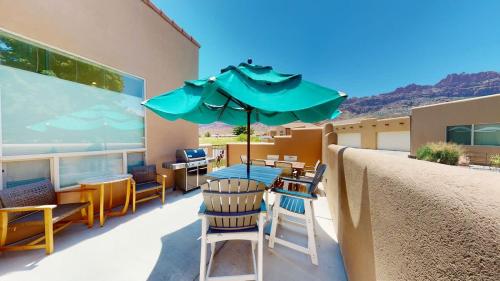 a patio with a table and chairs and an umbrella at Grey Pearl #Q3 in Moab