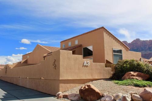 a house in the desert with mountains in the background at Arches Abode #A3 in Moab