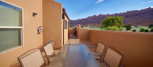 a table and chairs on a balcony with a view at Mountain Paradise #G3 in Moab