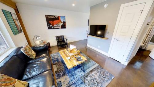 a living room with a leather couch and a table at Moab Flats #3 in Moab