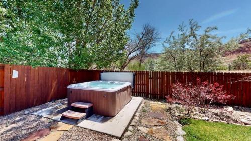 a hot tub in a yard next to a fence at Portal Vista #443 in Moab