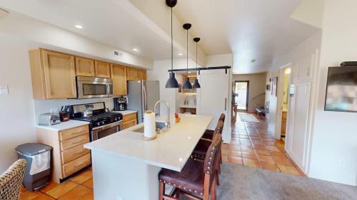 a kitchen with a white counter top and wooden cabinets at Henning's Escape #3328 in Moab