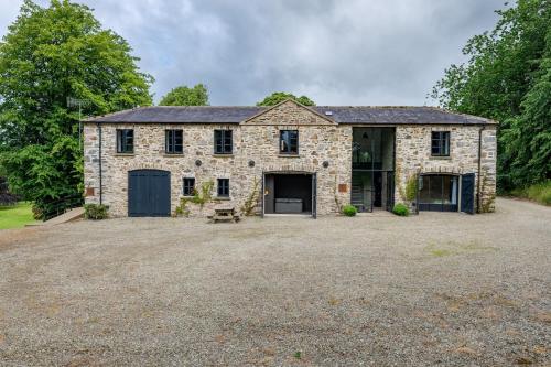 an old stone house with a large driveway at The Stables in Bearney
