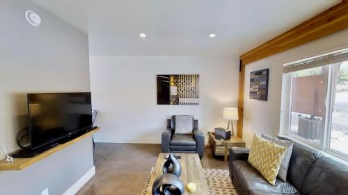 ein Wohnzimmer mit Sofa und Flachbildfernseher in der Unterkunft Moab Flats #2 in Moab