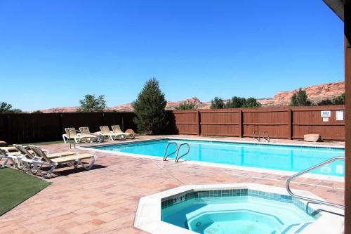 a large swimming pool with chairs and a swimming pool at Jan's Joy #N3 in Moab