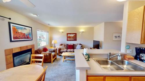a kitchen with a sink and a living room at River Days #3326 in Moab