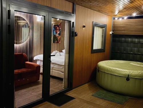 a bedroom with a bed and a tub in a room at Feli Lodge in Bosanska Gradiška