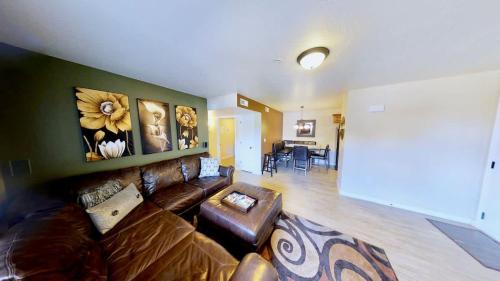a living room with a brown leather couch and a table at Red Cliff Condos #1B in Moab