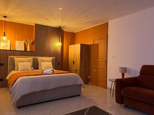 a bedroom with a large bed and a couch at Studio Cosy tout équipé 40m2 - Entrée autonome - Parking gratuit in Distroff