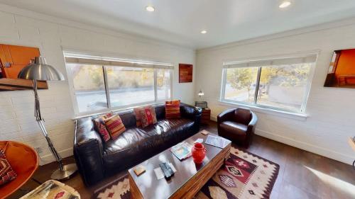 a living room with a leather couch and a table at Moab Flats #5 in Moab