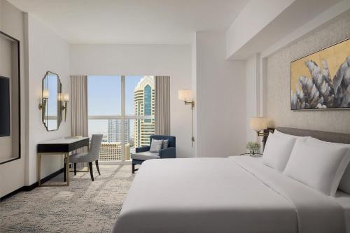 a hotel room with a bed and a desk at Dusit Thani Dubai in Dubai