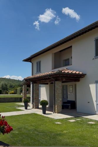 a white house with a wooden pergola at Il Cerro in Arezzo