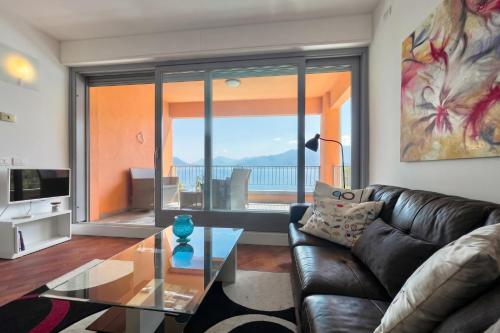 a living room with a leather couch and a glass table at Gaeta 'Lake View' in San Siro