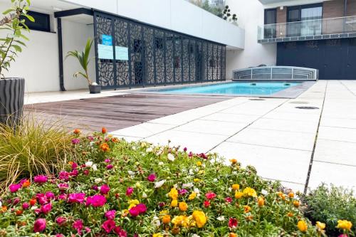 a swimming pool with flowers in front of a building at Sunset Resort 409 With Pool - Happy Rentals in Fonyód