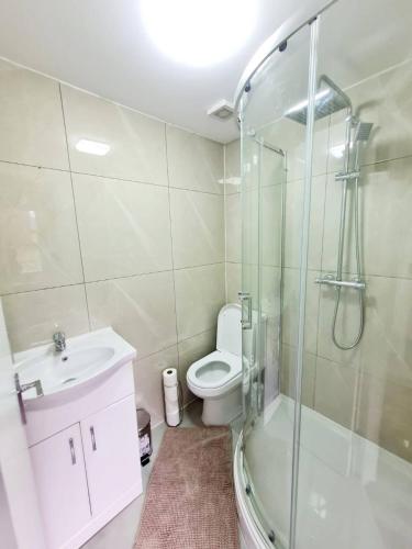 a bathroom with a shower and a toilet and a sink at Comfortable 2 Bed Apartment- Pass the Keys in Basildon