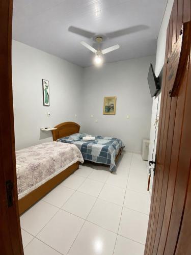 a bedroom with a bed and a ceiling fan at Pousada Recanto da Serrinha in Corumbá de Goiás