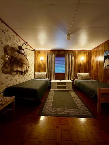 a hotel room with two beds and a window at Fjord Haven in Gryllefjord