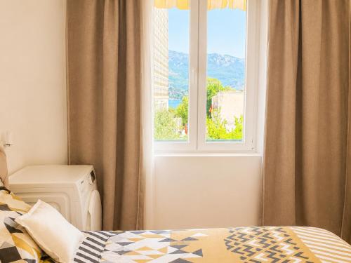 a bedroom with a bed and a window with a view at Alex Apartments in Budva