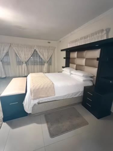 a bedroom with a large bed with a large headboard at 55 On Paisley in Bulawayo