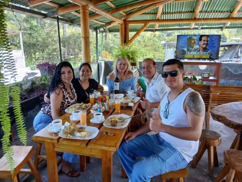 a group of people sitting around a wooden table at GoldenBird Mindo in Mindo
