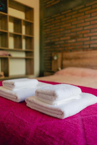 three towels are sitting on a pink table at Entre Campos in Los Reartes