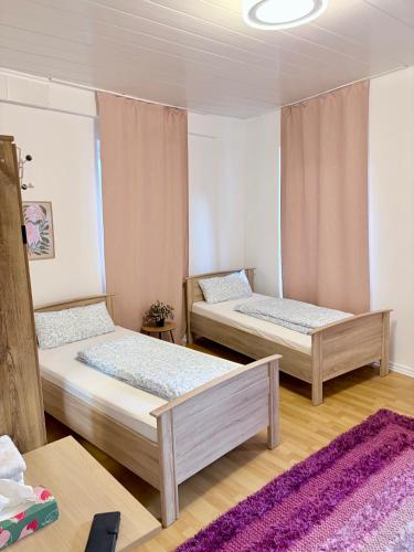 a room with two beds and a purple rug at Ferienwohnung Kinheim an der Mosel in Kinheim