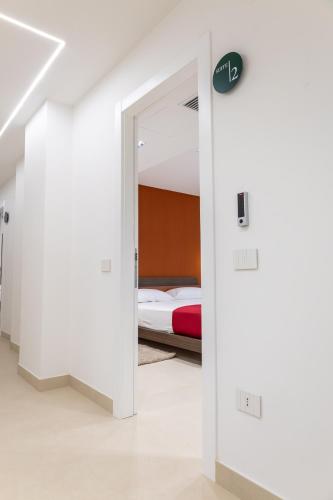 a white room with a bed and a door at Villa delle Rose Pompei Rooms and Suite in Pompei