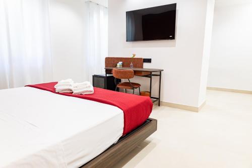 a bedroom with a bed and a desk and a television at Villa delle Rose Pompei Rooms and Suite in Pompei