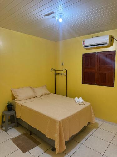 a bedroom with a bed and a air conditioner on the ceiling at Casa Fronteira in Oiapoque