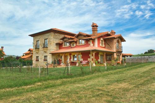 a large house in a field with a fence at Posada La Fabula in Santillana del Mar