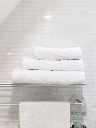 a stack of towels on a towel rack in a bathroom at Ganalé Hôtel in Dakar