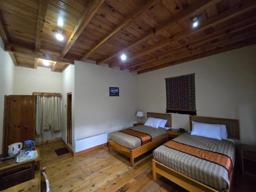 two beds in a room with wooden floors and wooden ceilings at Dream Janka Boutique in Paro