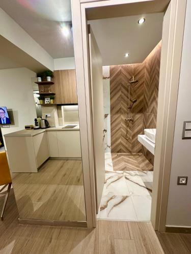 a bathroom with a walk in shower next to a kitchen at SMART COASTAL RETREAT Apartment in Alexandroupoli