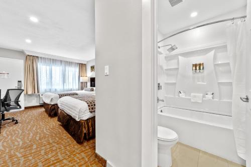 a hotel room with a bed and a bathroom at The Snoozzz Inn in Eureka
