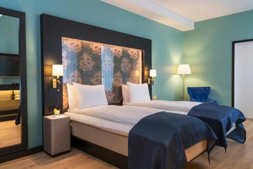 a bedroom with a large bed with a blue wall at Thon Hotel Terminus in Oslo