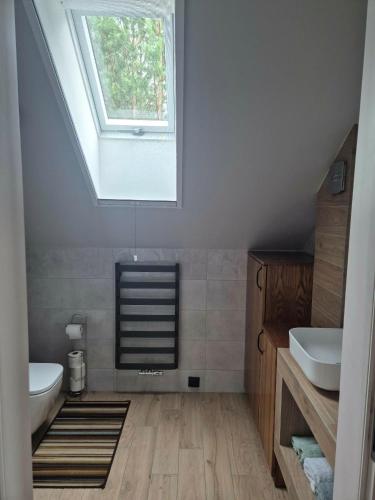 a bathroom with two sinks and a skylight at Dom za wydmą in Nielbark