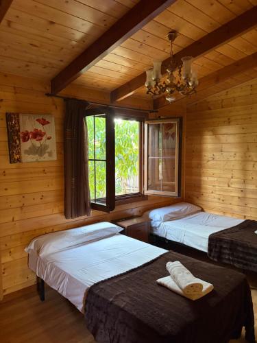 a bedroom with two beds in a log cabin at Apartamento El Paso in Fuentelisendo