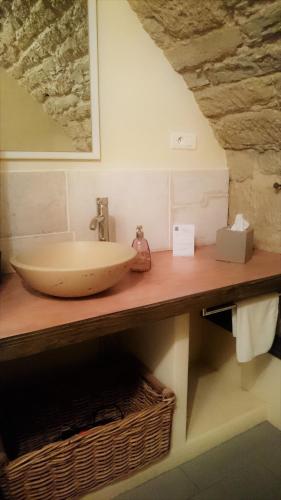 La salle de bains est pourvue d'un lavabo sur un comptoir en bois. dans l'établissement La Méridienne des Collines, à La Motte-de-Galaure