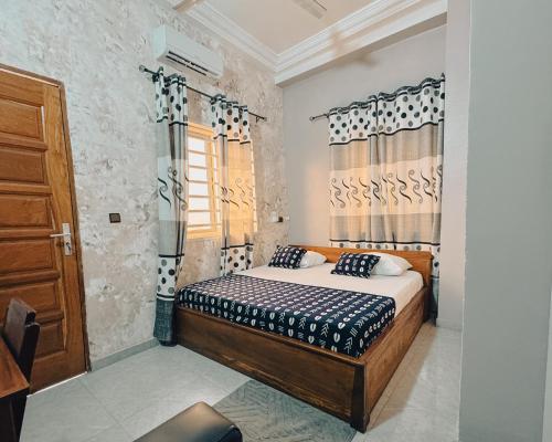 a bedroom with a bed and a window at Hôtel Merveille Lomé in Lomé