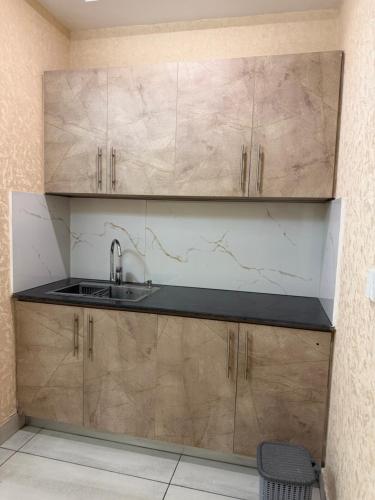 a kitchen with wooden cabinets and a sink at The Horizon Hotel Islamabad in Islamabad