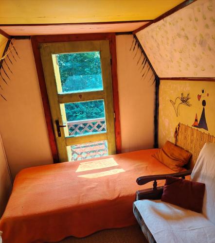 a small room with a bed and a window at Chata u Emi a Ivana in Tajov