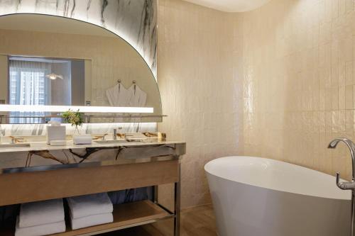 a bathroom with a tub and a large mirror at Andaz Miami Beach Resort & Spa in Miami Beach