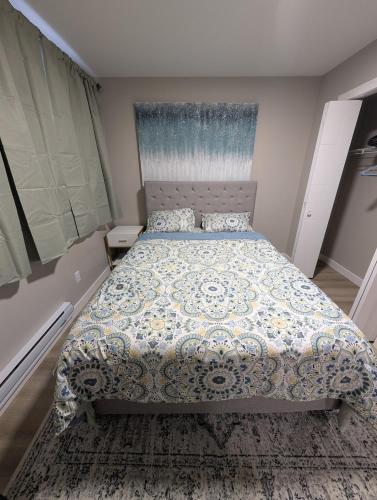 a bedroom with a bed with a comforter on it at Olas Place in Regina