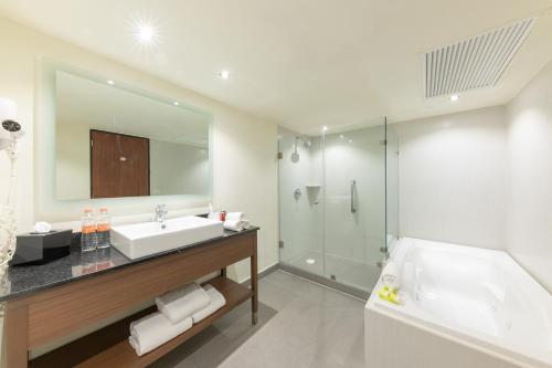 a bathroom with a sink and a tub and a mirror at Holiday Inn Guadalajara Expo Plaza del Sol by IHG in Guadalajara